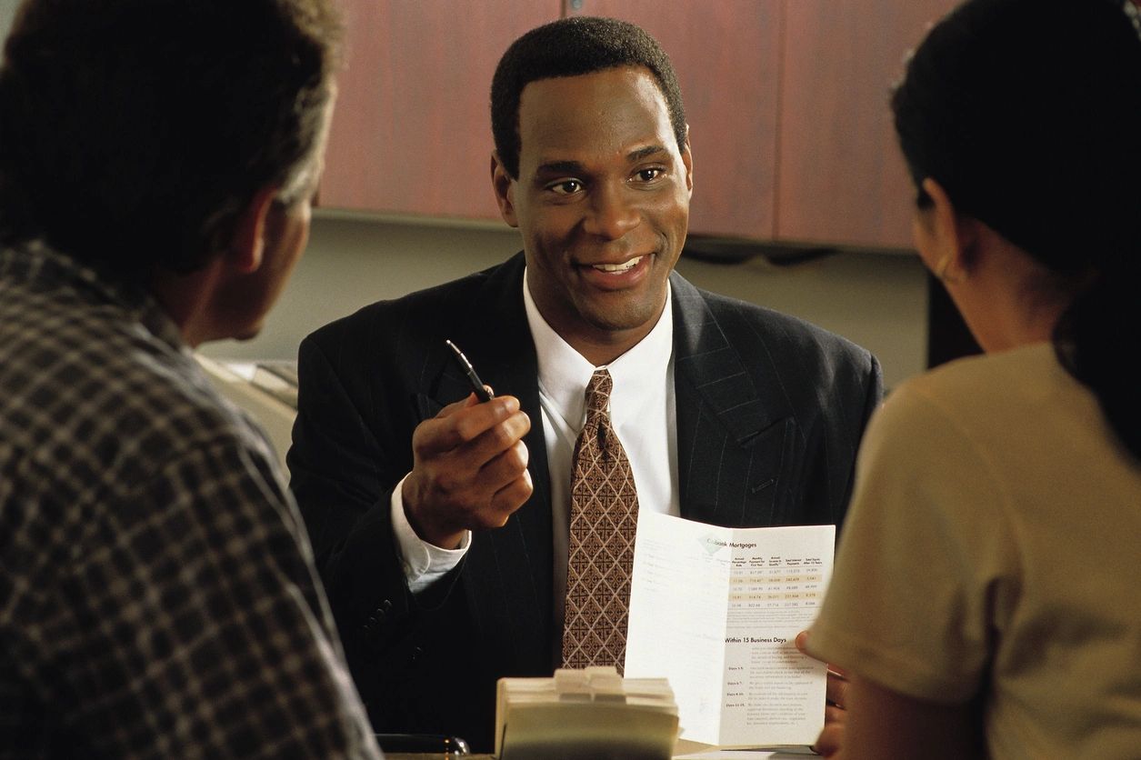 A man in black suit holding a pen